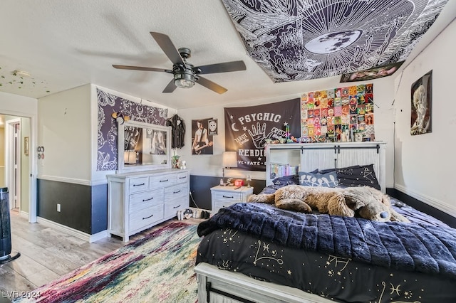 bedroom featuring ceiling fan, a textured ceiling, and light wood-type flooring