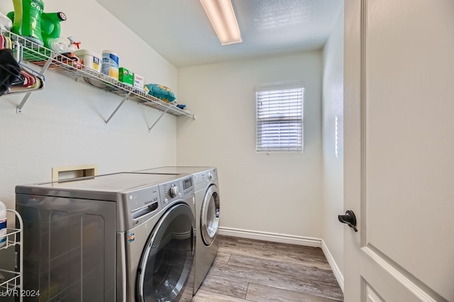 laundry room featuring washer and dryer and light wood-type flooring