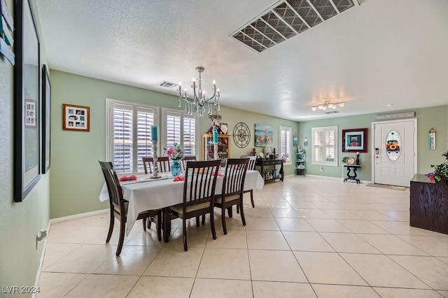 tiled dining area with a textured ceiling and a chandelier