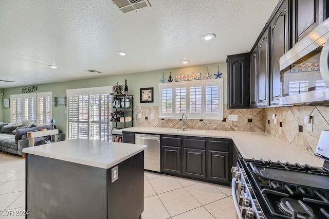 kitchen with light tile patterned floors, stainless steel appliances, sink, and a wealth of natural light