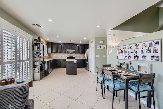 dining area with a notable chandelier, light tile patterned flooring, and sink