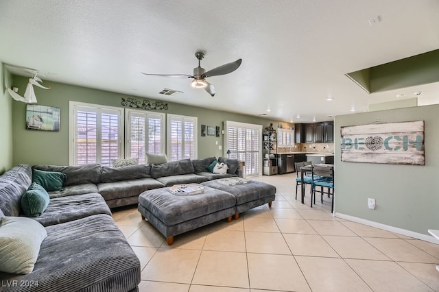 tiled living room featuring a textured ceiling and ceiling fan