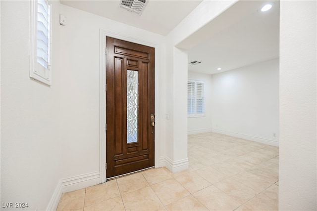 entryway with a wealth of natural light and light tile patterned floors