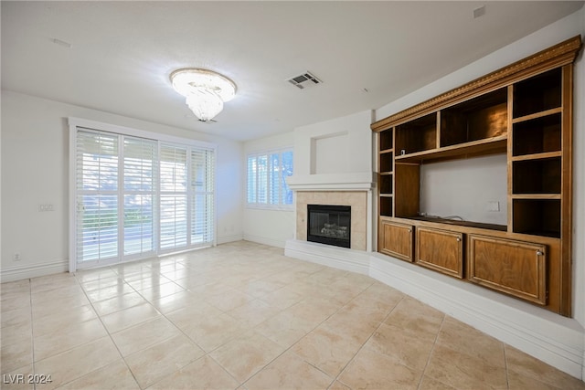 unfurnished living room featuring a tile fireplace and light tile patterned floors