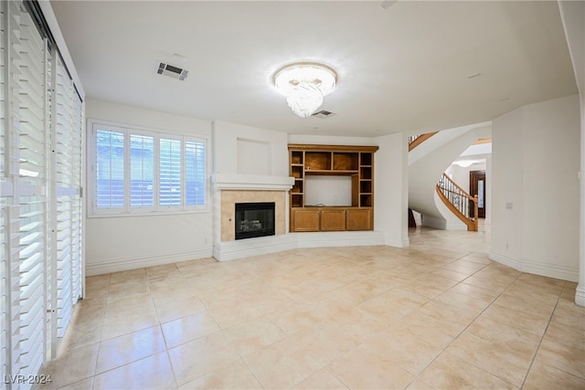 unfurnished living room with built in features and light tile patterned floors