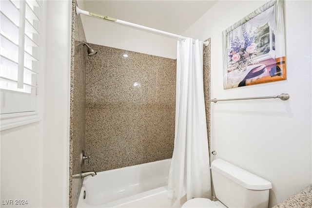 bathroom featuring shower / tub combo with curtain and toilet