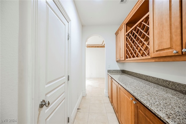 interior space with light tile patterned flooring and light stone counters