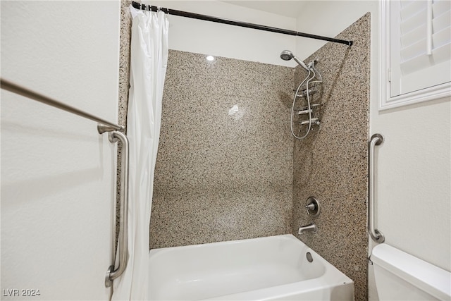 bathroom with shower / bath combo with shower curtain and toilet