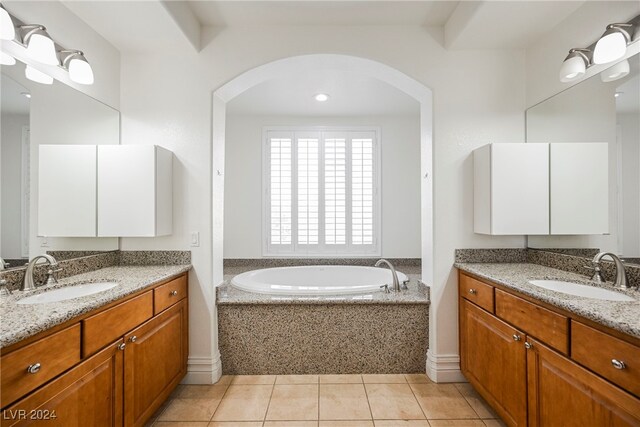 bathroom featuring vanity, tile patterned flooring, and tiled bath