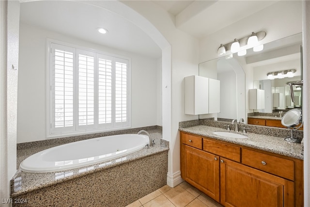 bathroom with vanity, a relaxing tiled tub, and tile patterned floors