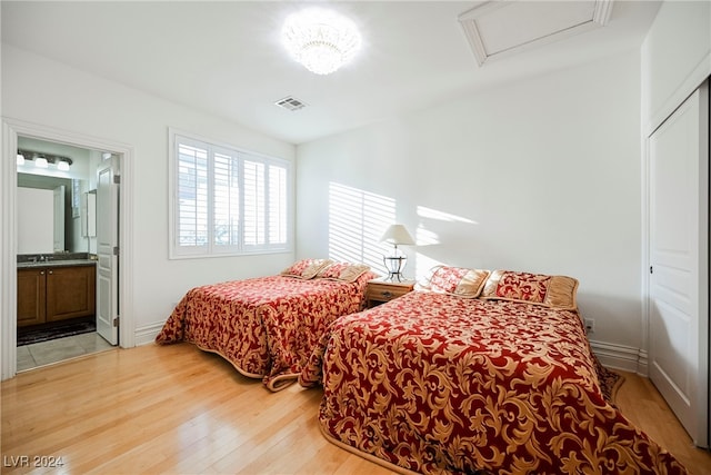 bedroom featuring connected bathroom, sink, and hardwood / wood-style floors