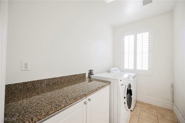 laundry area featuring washer and clothes dryer and light tile patterned floors