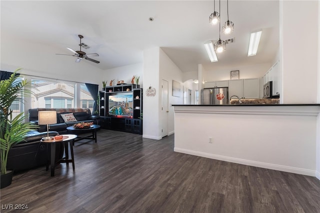 kitchen featuring vaulted ceiling, dark wood-type flooring, appliances with stainless steel finishes, and hanging light fixtures