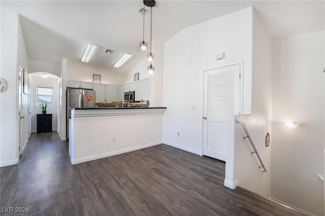 kitchen with lofted ceiling, decorative light fixtures, dark hardwood / wood-style floors, white cabinetry, and stainless steel appliances