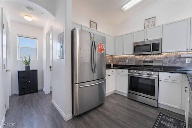 kitchen featuring lofted ceiling, white cabinetry, dark hardwood / wood-style flooring, stainless steel appliances, and backsplash