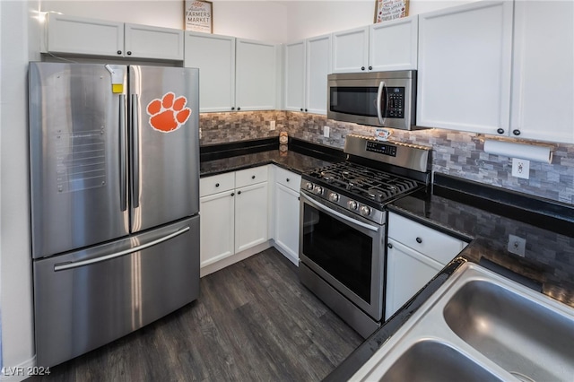 kitchen with white cabinets, dark wood-type flooring, stainless steel appliances, decorative backsplash, and sink