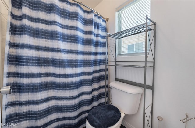 bathroom featuring toilet and walk in shower