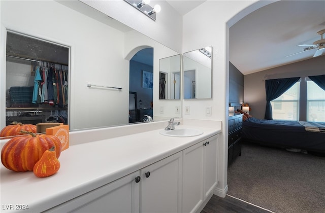 bathroom with vaulted ceiling, ceiling fan, hardwood / wood-style floors, and vanity