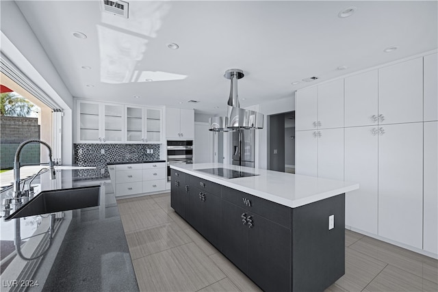 kitchen with pendant lighting, sink, a large island, white cabinetry, and black electric cooktop