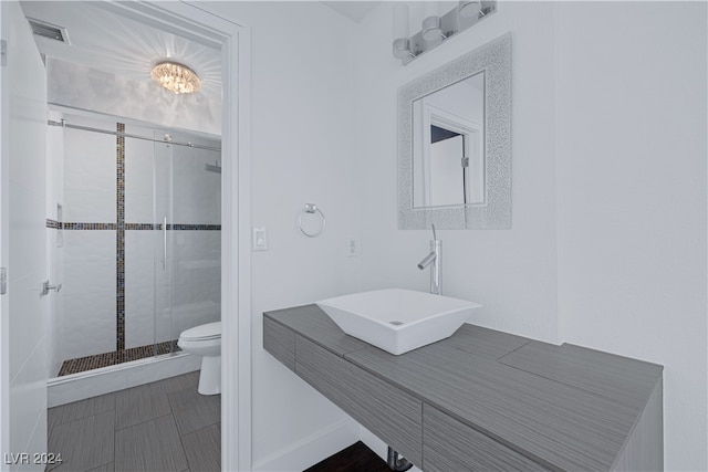 bathroom with vanity, a shower with shower door, and toilet