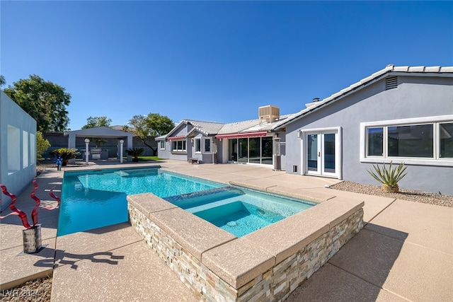 view of swimming pool featuring a patio and an in ground hot tub