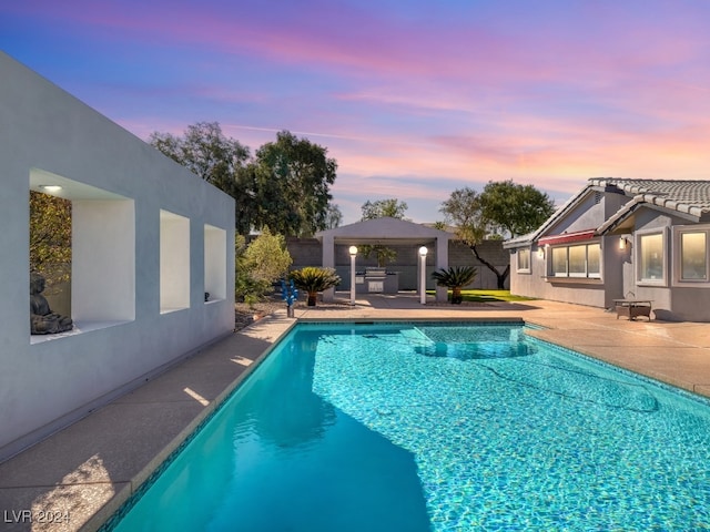 pool at dusk featuring a gazebo and a patio area