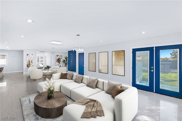 living room featuring a notable chandelier and french doors