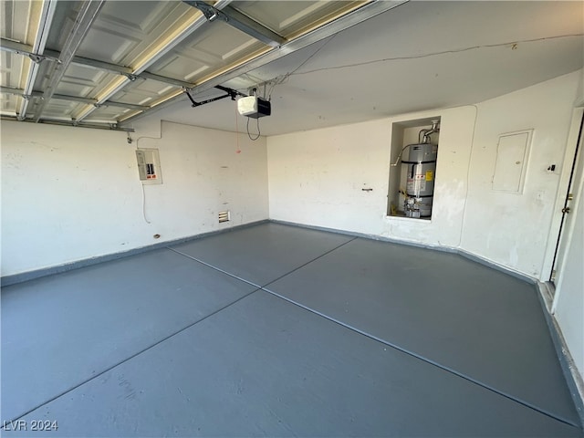 garage featuring a garage door opener, electric panel, and strapped water heater