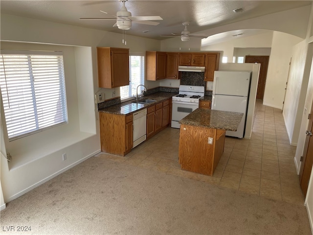 kitchen with white appliances, light colored carpet, a kitchen island, and sink