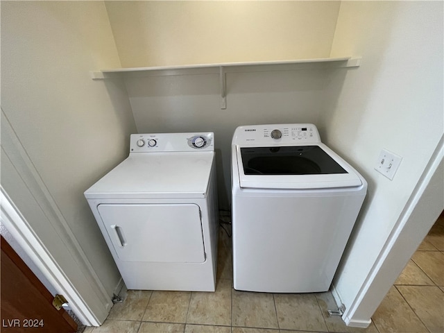 laundry area with light tile patterned flooring and washing machine and dryer