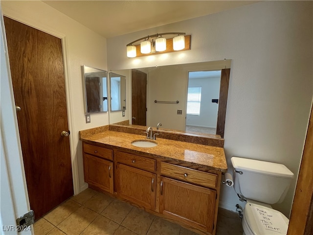 bathroom with vanity, tile patterned flooring, and toilet