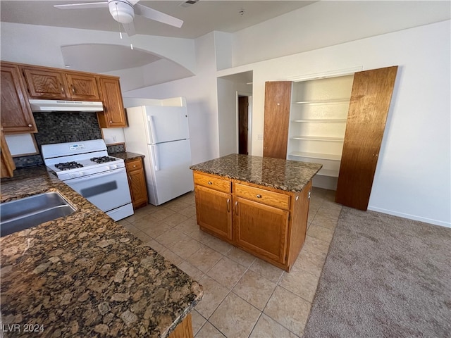 kitchen with a kitchen island, ceiling fan, white appliances, sink, and light tile patterned floors