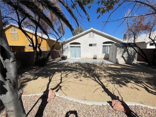 back of house featuring a shed and a patio area