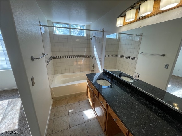 bathroom with tile patterned floors, vanity, and tiled shower / bath