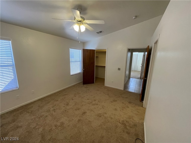 unfurnished bedroom with light carpet, lofted ceiling, multiple windows, and ceiling fan