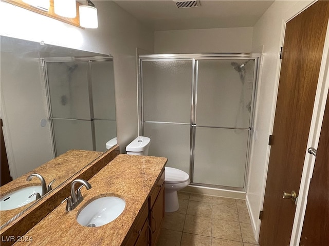 bathroom featuring tile patterned floors, an enclosed shower, vanity, and toilet