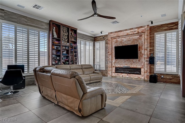 living room with a textured ceiling, a large fireplace, ceiling fan, and crown molding