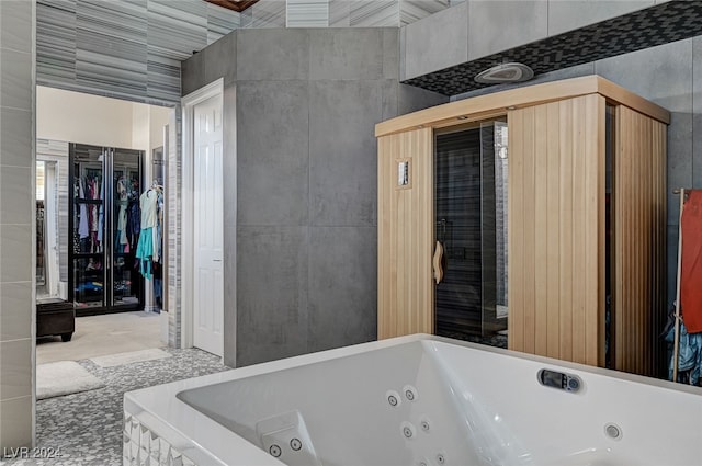 bathroom featuring tile walls and tiled tub