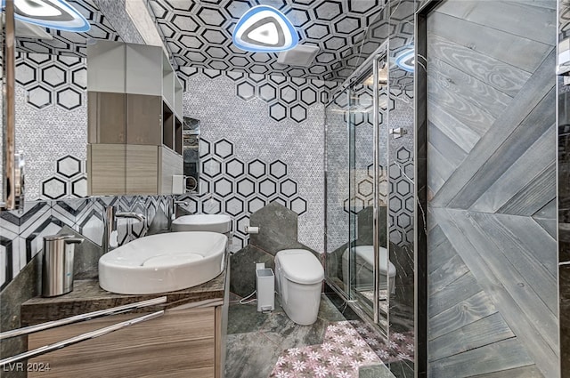 bathroom featuring tile walls, walk in shower, vanity, and toilet