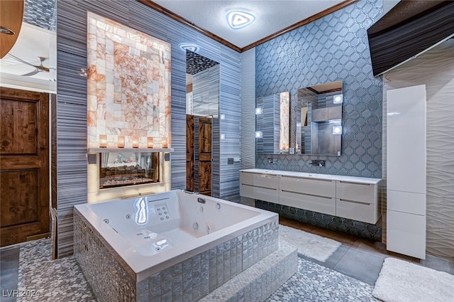 bathroom featuring tile patterned flooring, a textured ceiling, vanity, crown molding, and a relaxing tiled tub