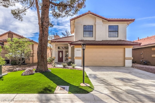 mediterranean / spanish house featuring a garage and a front lawn