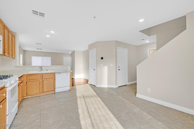 kitchen with white appliances, sink, and light tile patterned flooring