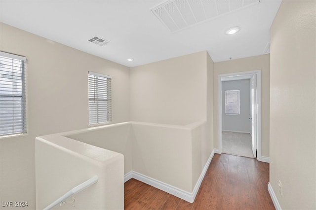 hallway with a wealth of natural light and dark wood-type flooring