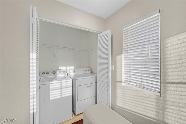 clothes washing area featuring washing machine and dryer and light tile patterned floors