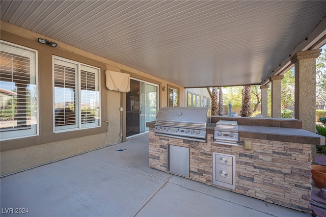 view of patio featuring exterior kitchen and a grill