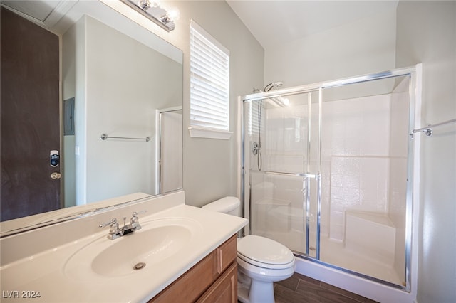 bathroom with vanity, toilet, wood-type flooring, and a shower with door