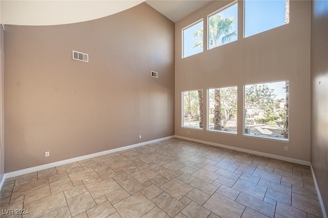 spare room featuring a high ceiling and plenty of natural light