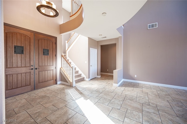 foyer with an inviting chandelier and a towering ceiling