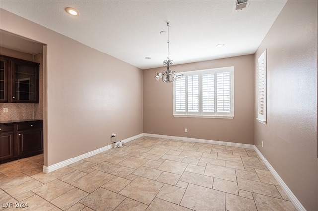 unfurnished dining area with a chandelier