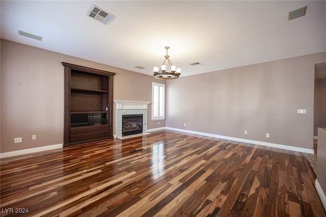 unfurnished living room featuring a notable chandelier and dark wood-type flooring